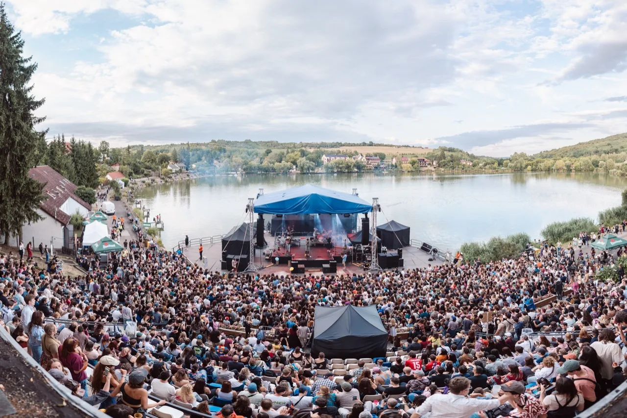 The Bánkitó festival main stage beside the lake, seen over the crowd